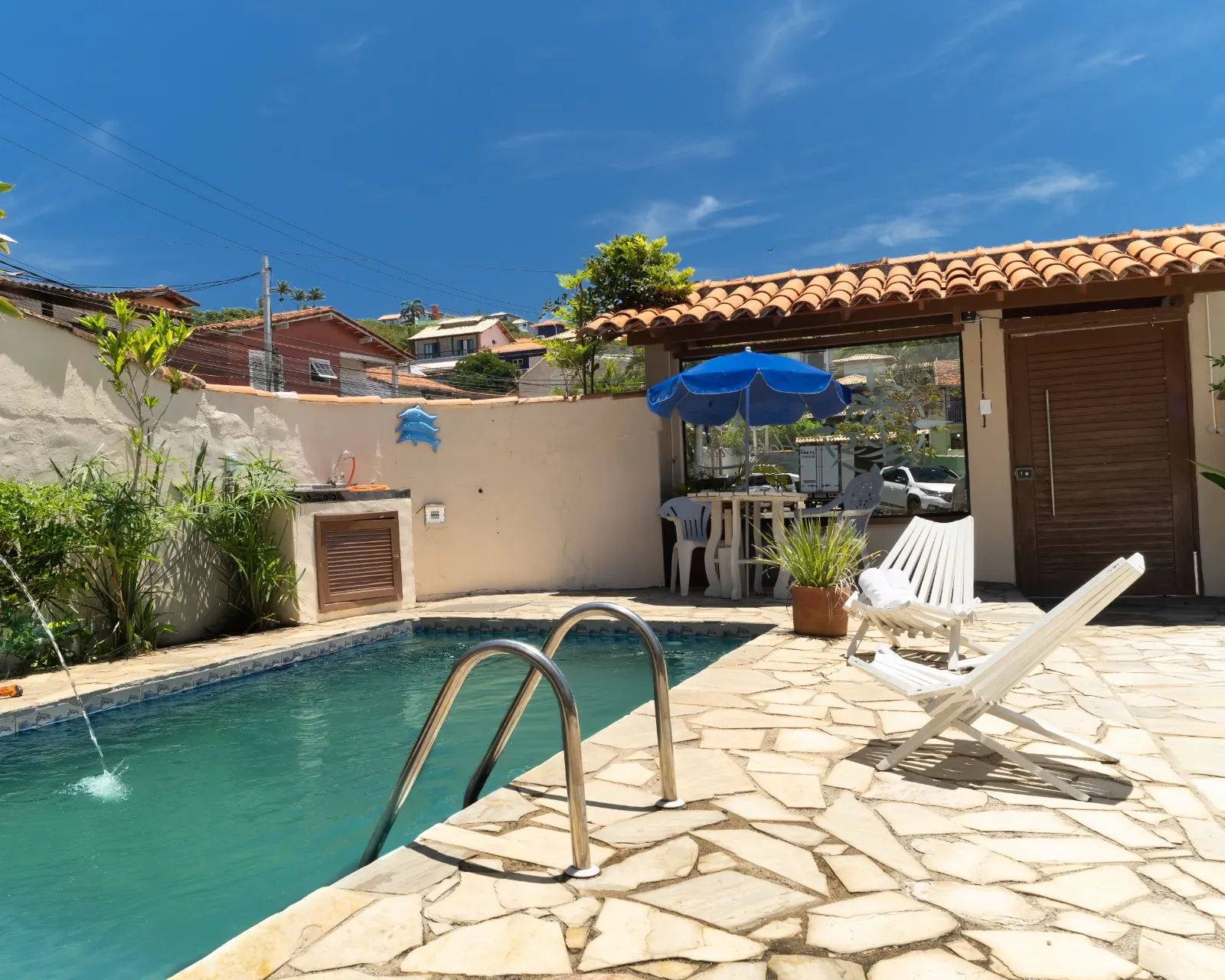 Piscina da Pousada GO Tartaruga com guarda-sóis azuis